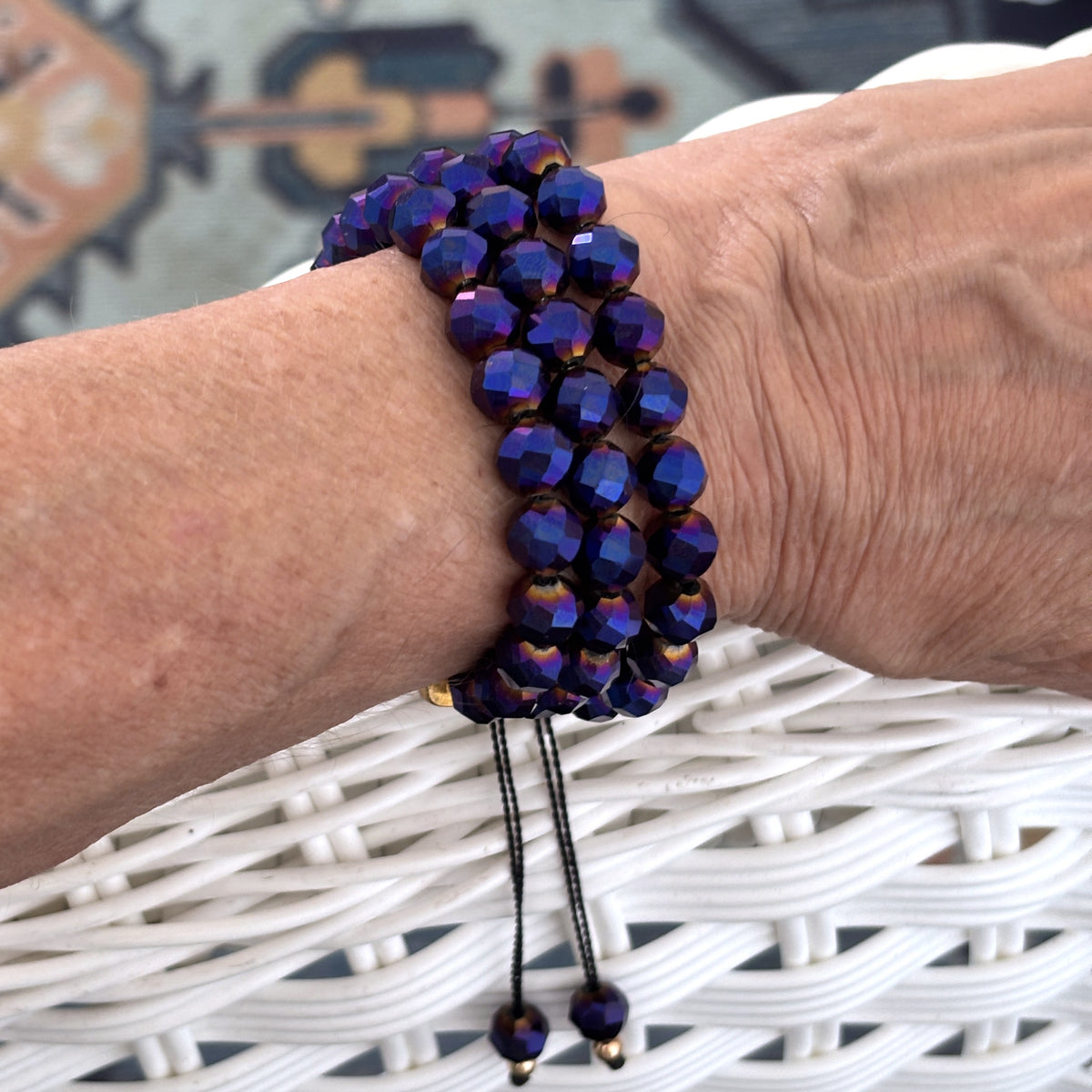 Cobalt blue vitrail glass bracelet worn on a wrist, showing its triple-strand design and adjustable closure.