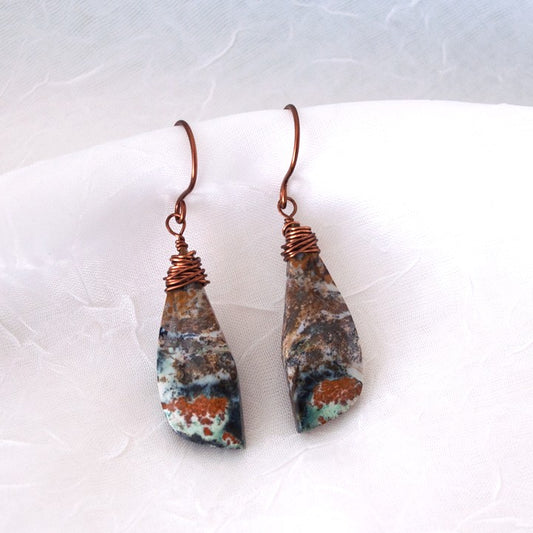 Pair of wire-wrapped ocean jasper earrings with copper wire wrapping and handcrafted ear wires, displayed against a white linen background
