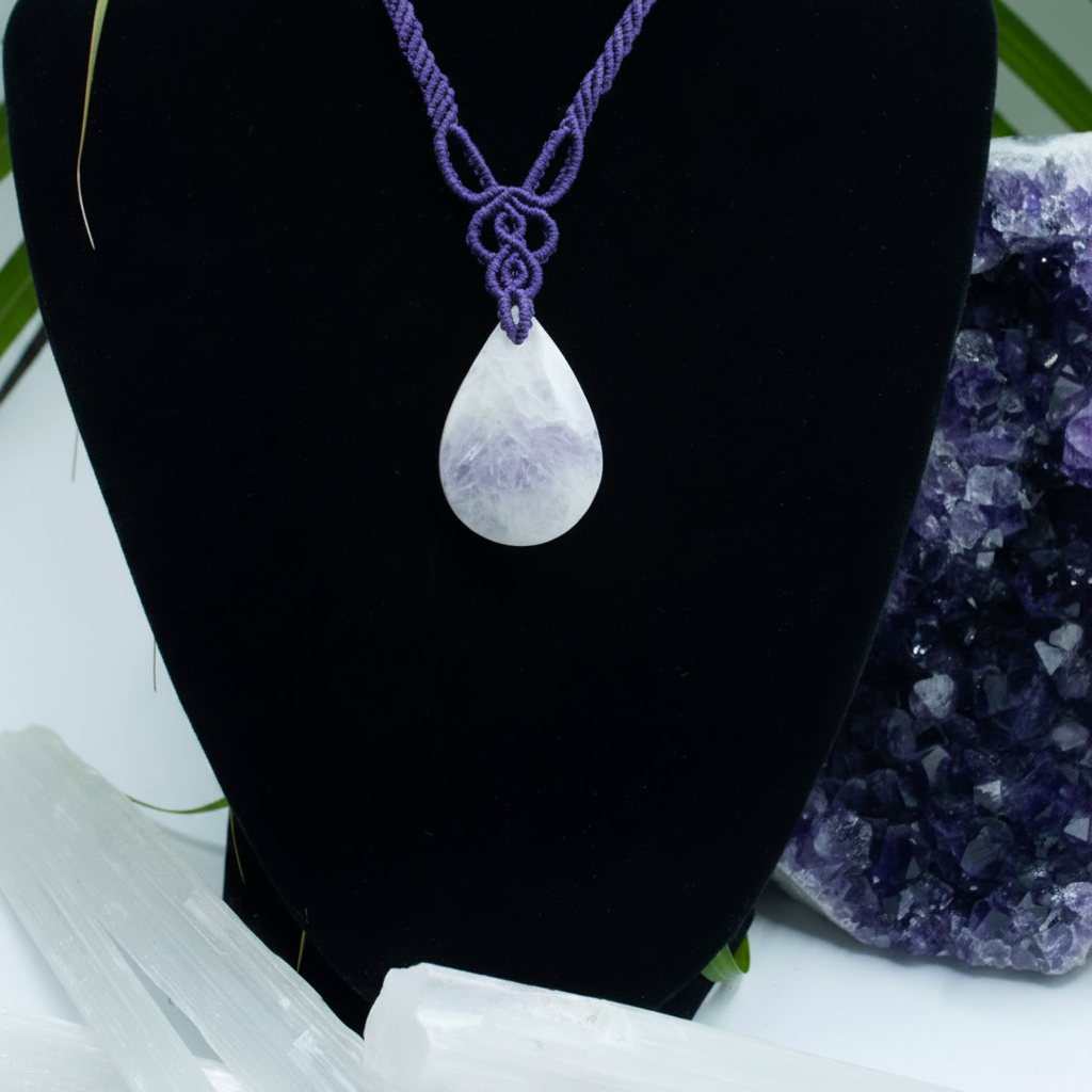 A purple macrame knot necklace with a teardrop-shaped Amethyst stone pendant, displayed on a black jewelry bust.
