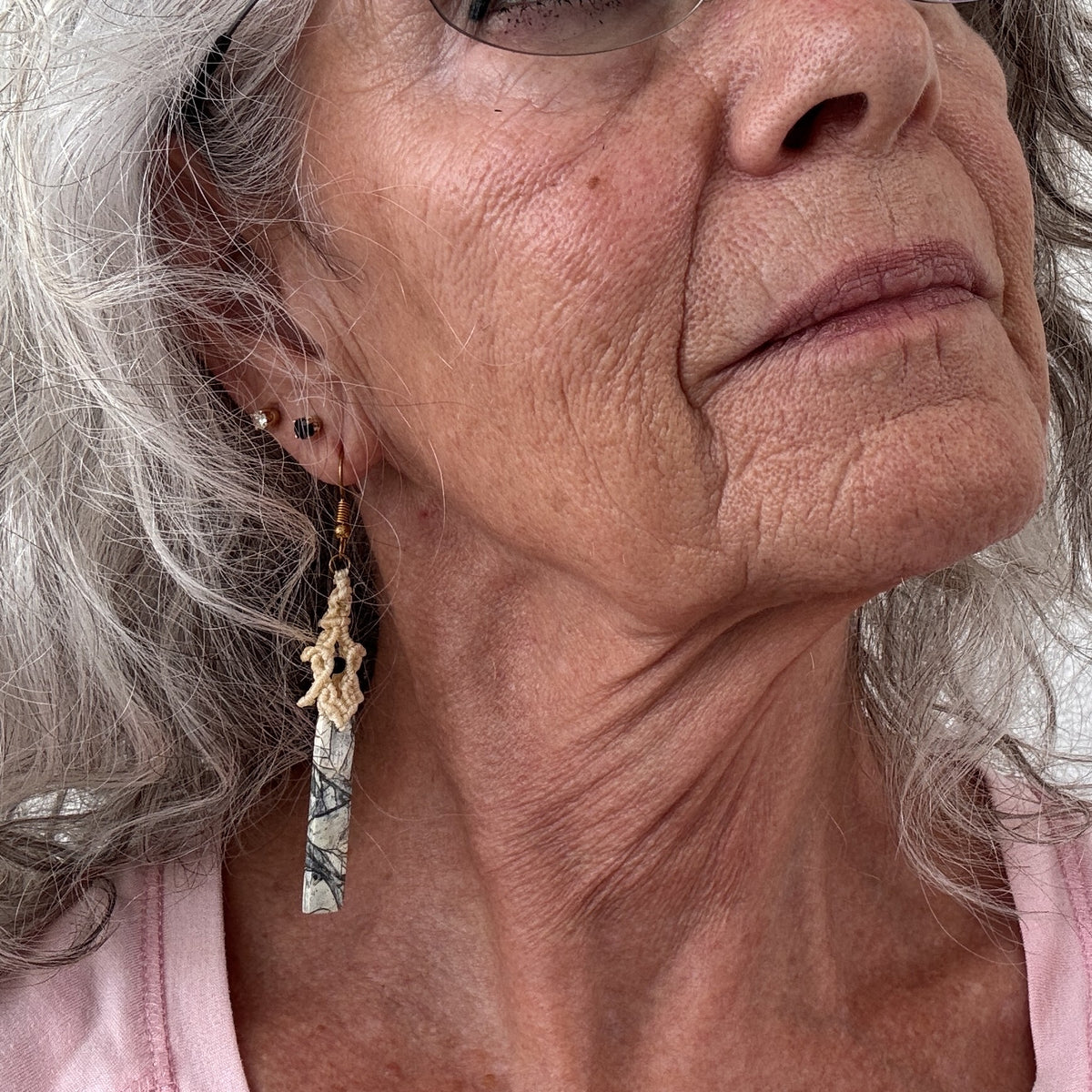 Pale yellow lace macrame pagoda earring with maligano jasper stick bead and matte black seed bead accent shown worn on model with silver hair