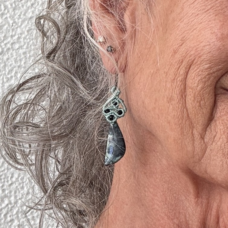 Teal macrame and Bacan stone dangle earring shown worn at the ear for scale