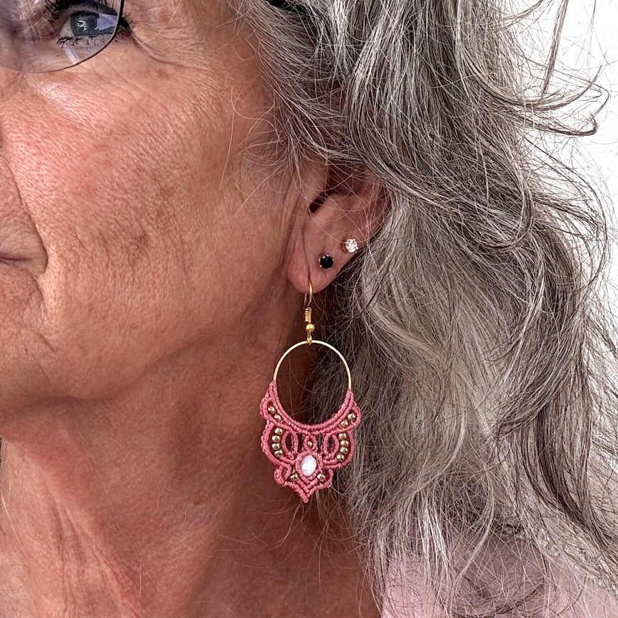 Pair of handmade two-tone turquoise and aqua macrame scroll drop earrings with turquoise mermaid glass bead centers and silver-tone metal bead accents, displayed on white fabric background.