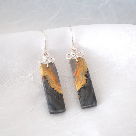 Handmade bumble bee jasper earrings with silver-tone handcrafted bail and ear wires, displayed on white linen surface showing charcoal and amber stone detail