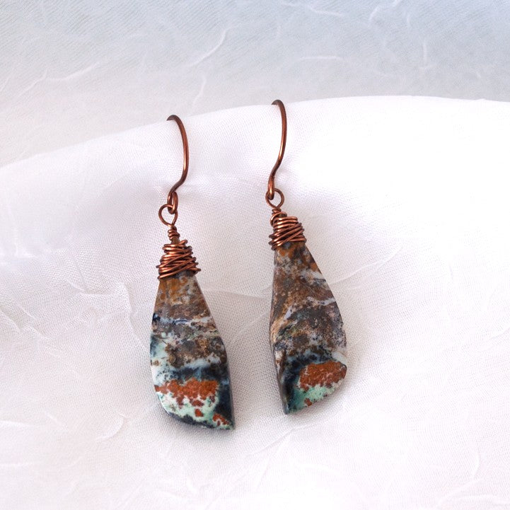 Pair of wire-wrapped ocean jasper earrings with copper wire wrapping and handcrafted ear wires, displayed against a white linen background
