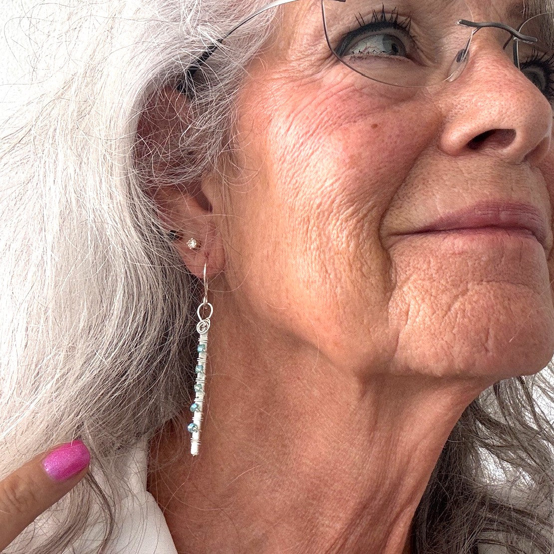 Aqua Swarovski crystal wire-wrapped bar earrings with hand-coiled silver-plate connecting ring shown worn on model with silver hair