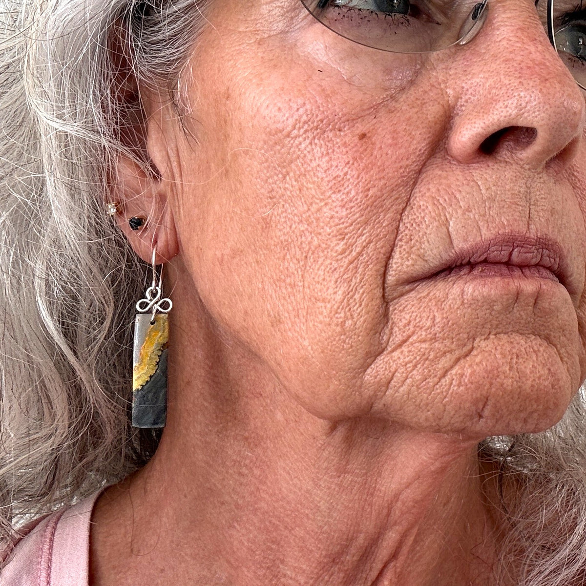 Bumble bee jasper earring with silver-tone handcrafted bail and ear wire shown worn on model with silver hair