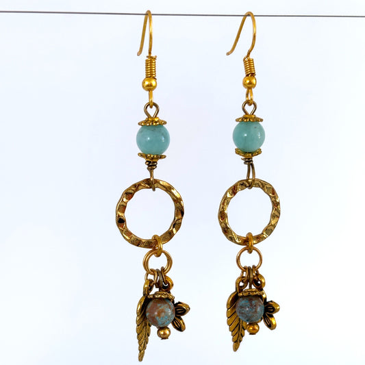 Handmade gold-tone textured ring earrings with amazonite bead, blue calsilica drop, and gold-tone leaf and flower charms, hanging against a white background