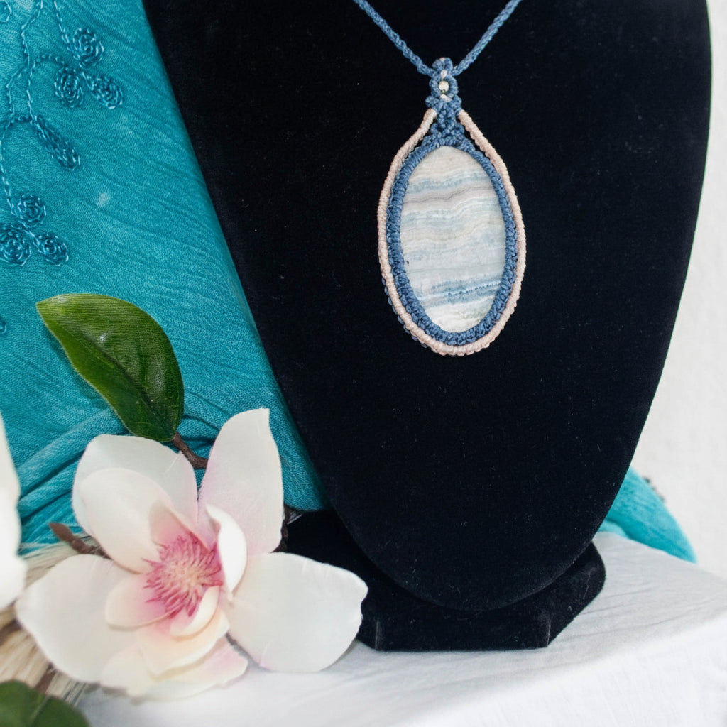 styled shot on black bust with teal fabric and magnolia flower, showing the two-tone macrame bezel detail